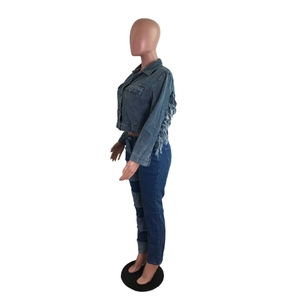 Détail de la veste en jean avec franges blanches au dos et d'un pantalon patchwork