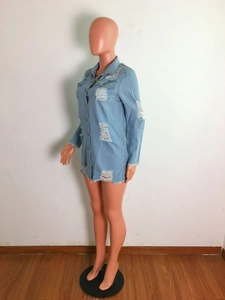 Detail of light blue denim coat showing distressed ripped holes and metallic buttons