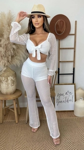 Detailed texture of white mesh long sleeve tie-front crop top and flared beach pants