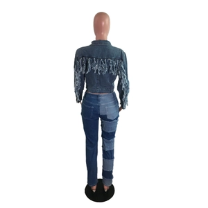 Gros plan sur une veste courte en jean avec de longues franges sur les manches et le dos