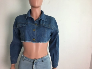 Détail de la veste en jean courte avec ourlet effiloché et boutons dorés rétro