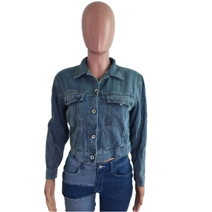 Détail de la veste en jean courte avec col classique et poches à rabat boutonnées