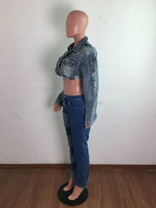 Détail de la veste en jean usée avec ourlet effiloché et textures déchirées