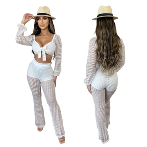 Detail view of the white mesh two-piece set featuring lace-up top and flare pants