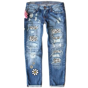 Mid-rise straight leg jeans in washed blue with daisy patches and leopard print rips
