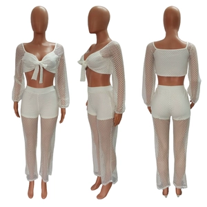 Detail view of white crochet mesh two-piece set with crop top and long pants