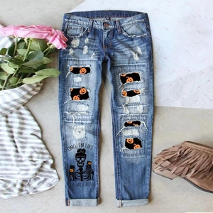 Detail of distressed jeans with Halloween pumpkin print lining and skull slogan print