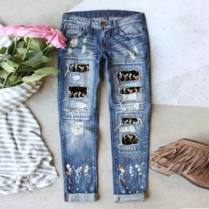 Women's ripped denim jeans with Halloween pumpkin and skull prints in dark blue wash