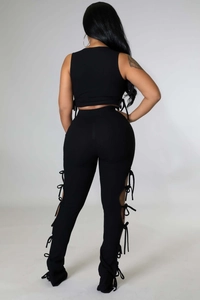 Λεπτομέρεια μαύρου αμάνικου crop top και ψηλόμεσου παντελονιού με πλαϊνά κορδόνια