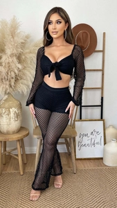 Detail of black mesh two-piece set featuring tie-front crop top and flared pants