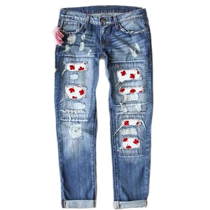 Women's blue distressed straight leg jeans with red maple leaf print patches
