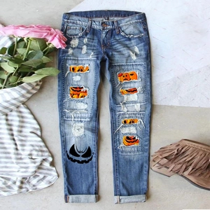 Women's blue distressed jeans with Halloween pumpkin print patches and monster graphic