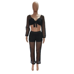 Close-up of black mesh two-piece set featuring a large bow-tie crop top and matching pants