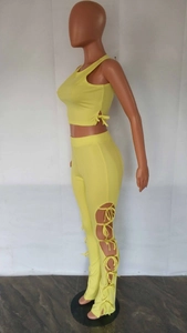 Λεπτομέρεια από κίτρινο ριμπ crop top με κορδόνια και ασορτί παντελόνι με ανοίγματα