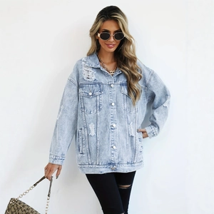 Détail de la veste en jean bleu clair avec finitions déchirées et boutons en métal