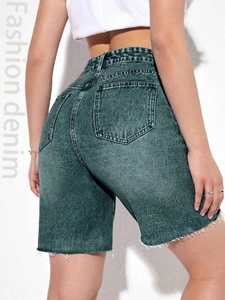Close-up of high-waisted dark green denim shorts featuring frayed hems and back pockets