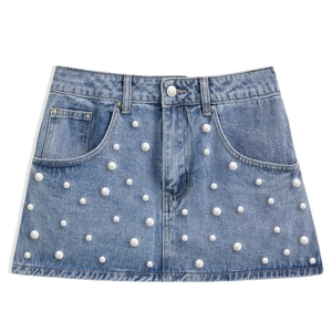 Detailed view of light blue denim mini skirt with scattered white pearl embellishments