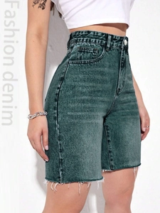 Detail view of high-waisted dark grey washed denim shorts with raw hem fringe and pockets