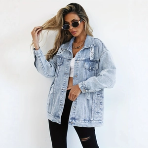 Détail d'une veste en jean oversize bleu clair délavée avec boutons et poches de poitrine