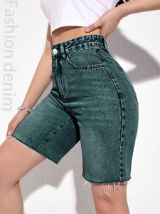 Detail of high waisted denim bermuda shorts with washed finish and raw hem edges