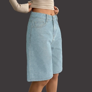 Detail view of high waisted light blue denim shorts with five pockets and zip fly closure