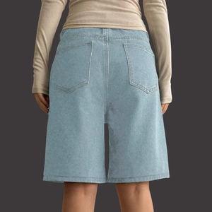 Detail of light blue washed denim shorts with large back pockets and high-waist fit