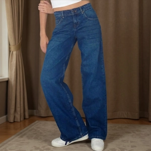 Detailed shot of dark blue denim wide leg trousers with high waist design and metal button