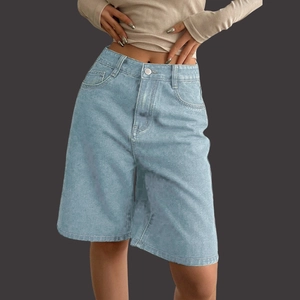 Detail of high waisted light blue denim Bermuda shorts with metal button and side pockets