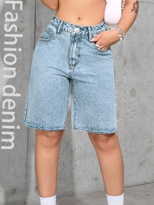 Close-up of high-waisted denim shorts featuring vintage wash and distressed raw hem detail