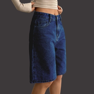 Close-up of high-waist denim bermuda shorts showing side tailoring and fabric texture