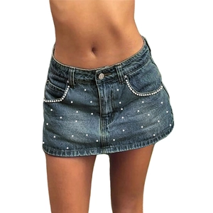 Detailed view of dark blue denim mini skirt with elegant pearl embellishments on pocket
