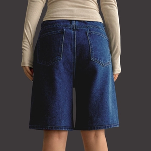 Detail view of high waist denim shorts with back pockets and vintage wash finish