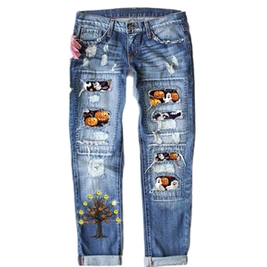 Women's mid-rise ripped denim jeans featuring Halloween pumpkin and ghost print patches