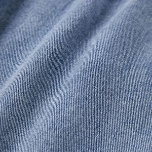 Detailed view of blue denim fabric with twill weave and natural washed texture