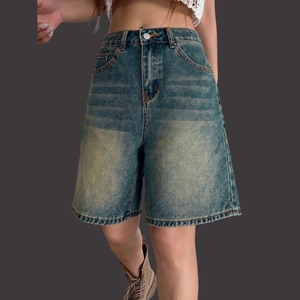 Detailed macro of vintage blue wash denim texture and front button on high waist shorts