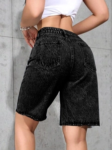 Detail view of high-waisted black denim Bermuda shorts with frayed hems and back pockets
