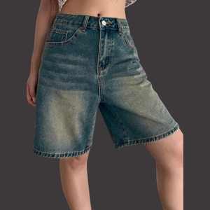 Detail of high-waisted denim shorts in retro stone wash with classic five-pocket design