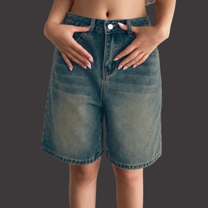 Detail of vintage washed blue denim shorts with whiskering and silver metal button closure