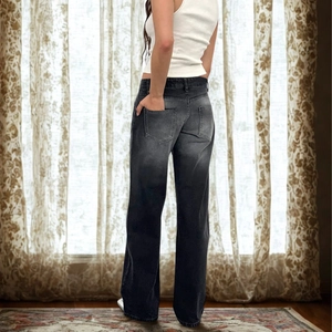 Detail view of high-waisted wide-leg jeans in washed grey with vintage fade and back pockets
