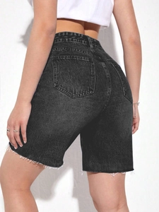 Close-up of black high-waisted denim shorts featuring raw hem fringe and back pockets