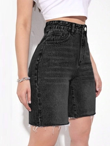 Detail shot of high-waisted denim shorts featuring raw hems and washed fabric texture