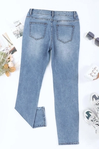 Detail of light blue washed denim pants with back pockets and casual laid-out flat lay style