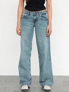 Detail view of light blue vintage wash denim fabric and wide leg cut on these jeans