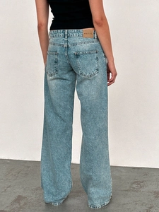 Close-up of the back pockets and MOTEL brand leather patch on light blue wide leg jeans