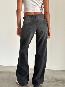 Detail showing back pockets and washed texture of vintage wide-leg denim trousers