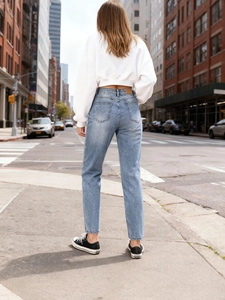 Light blue distressed denim jeans for women with back pocket detail and slim fit style