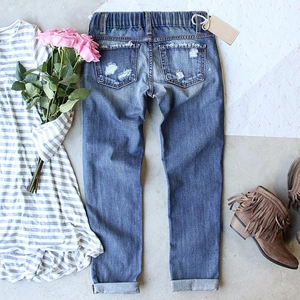 Distressed blue stretch denim jeans with elastic waist and stylish ripped detailing
