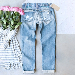 Flat lay of elastic waist distressed straight-leg denim jeans with cuffed hems and floral accents