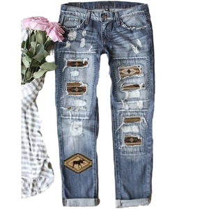 Women's vintage blue ripped jeans with bohemian print patches and deer embroidery detail