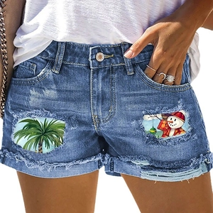 Women's mid-waist denim shorts with distressed rips, cuffed hems, and tropical palm prints